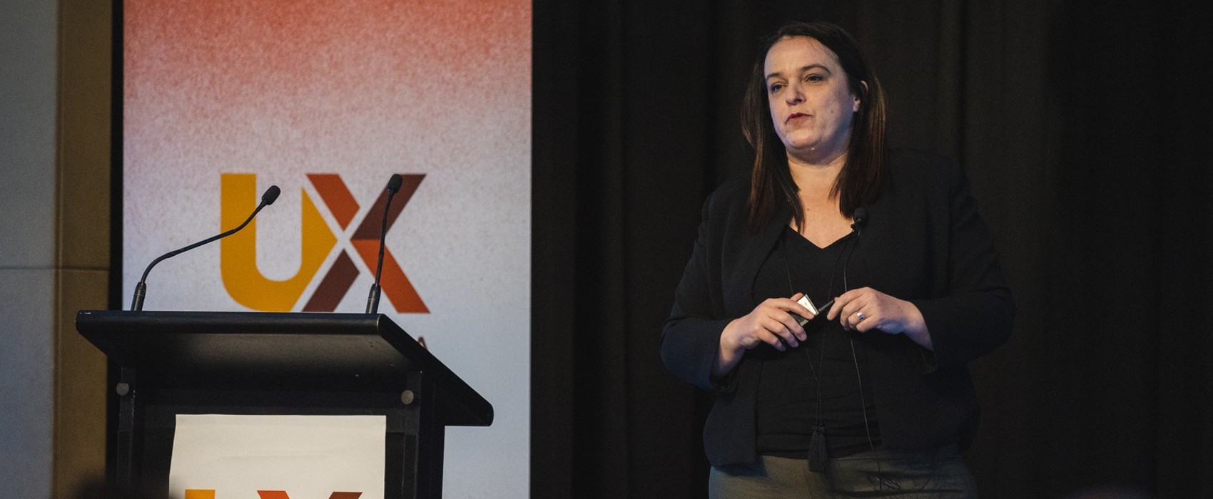 Fiona Armstrong speaking on stage at UX Australia 2022.